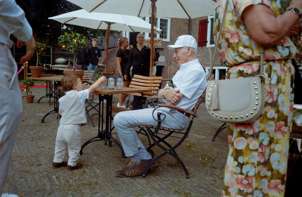 analoge trouwfotografie op een bruiloft met een opa en zijn kleinzoon